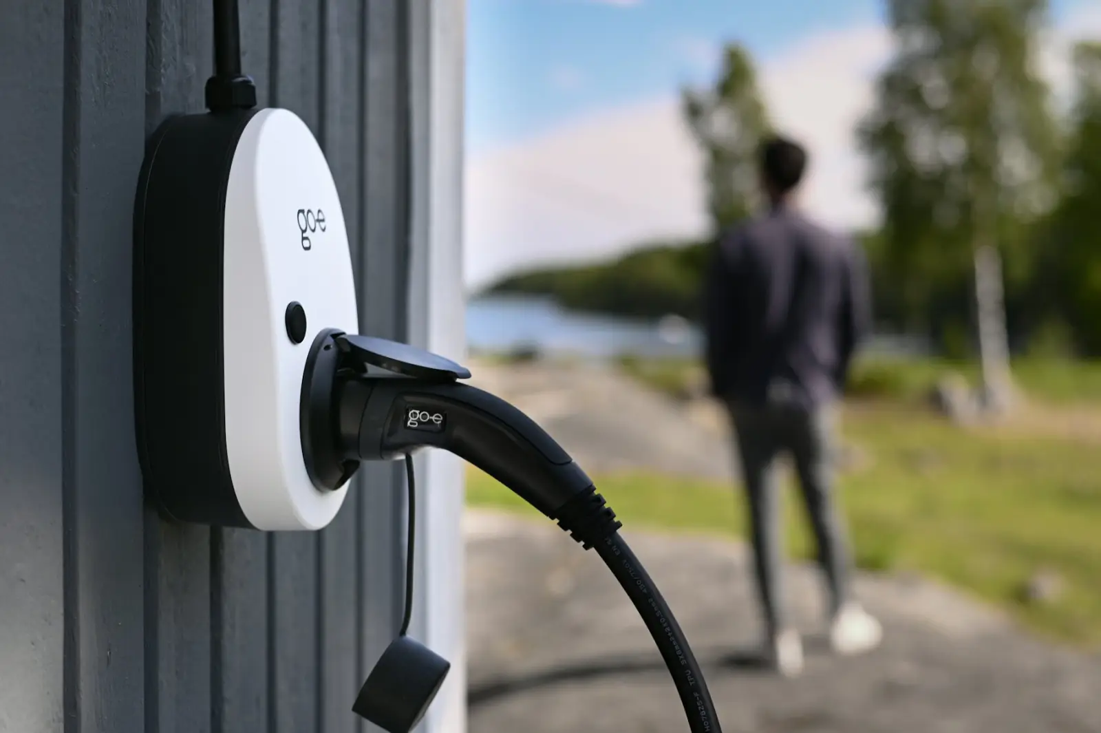 Wallbox an einer Hauswand mit eingestecktem Ladekabel